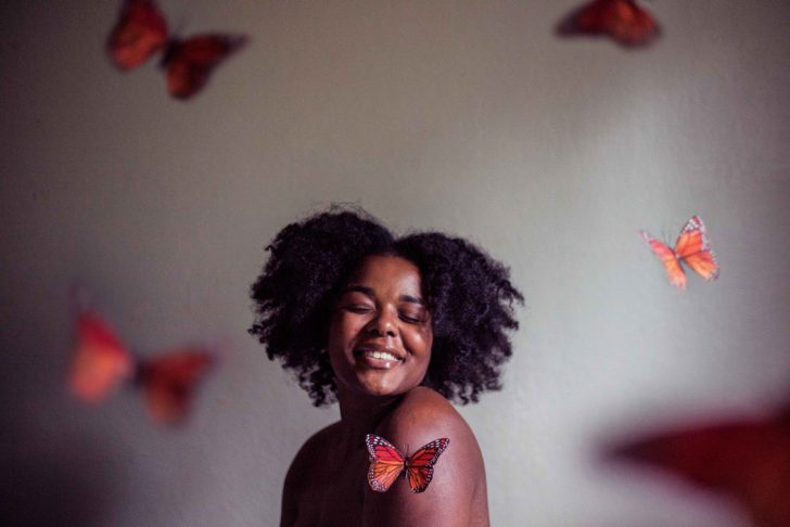 Meisje in een kamer lachend met vlinders, geluk, gelukkig zijn
