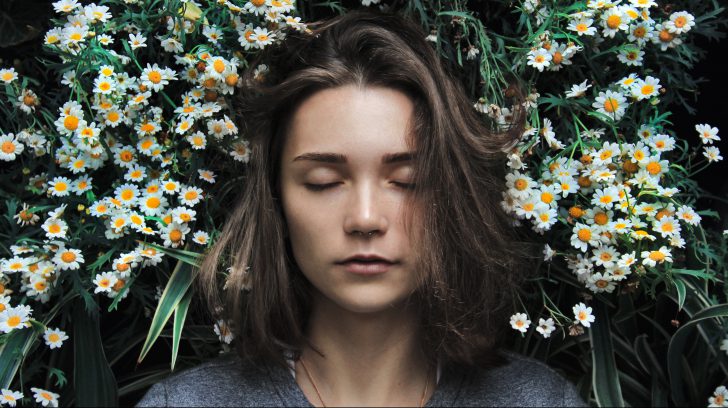 meisje ligt in een bloemenveld