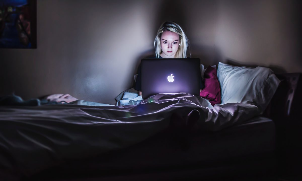 meisje met werkverslaving werkt laat in bed