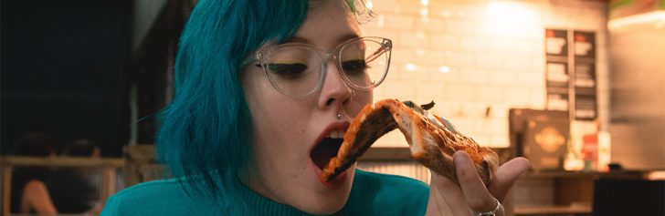 vrouw eet pizza