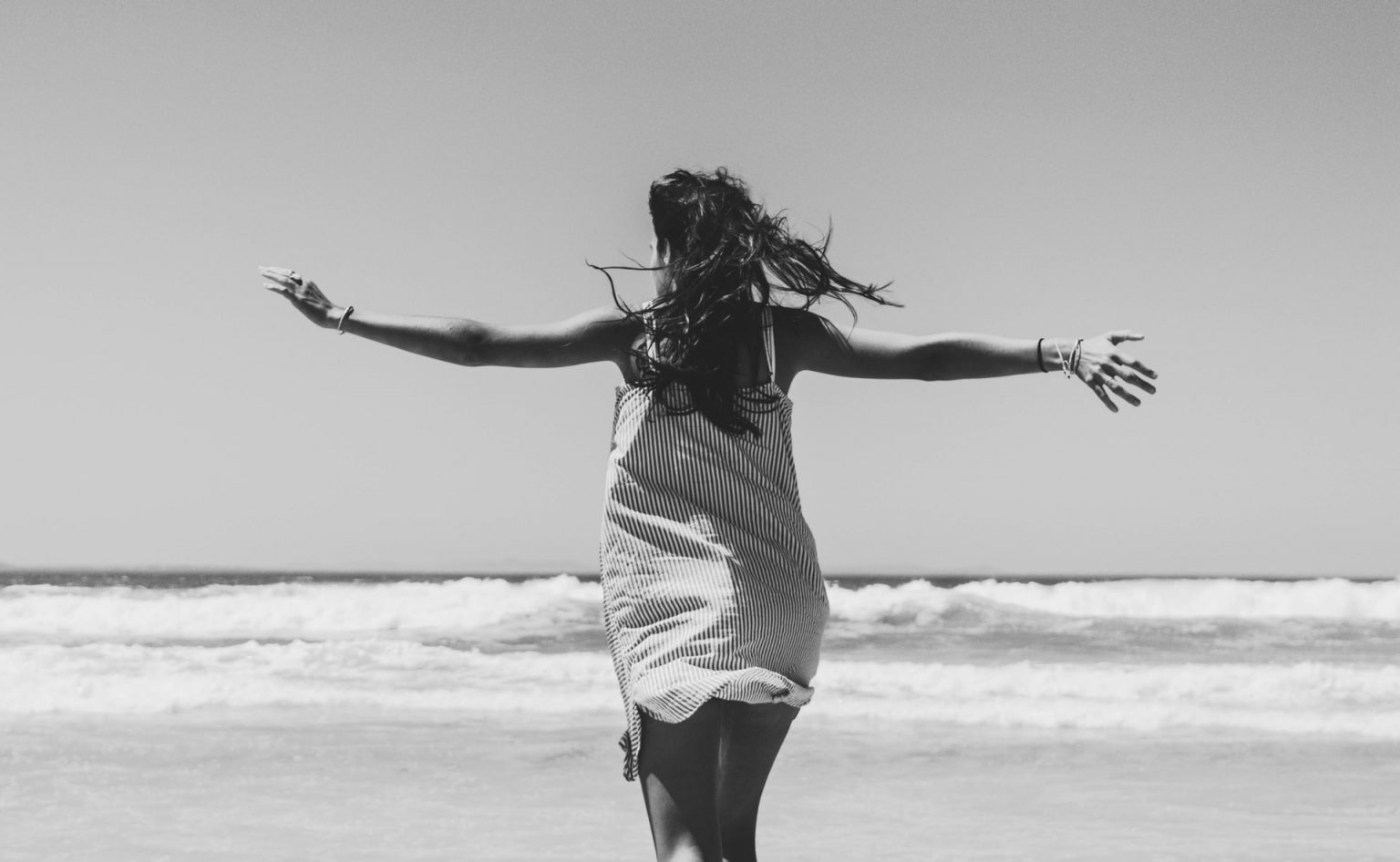 vrouw is blij en loopt over het strand