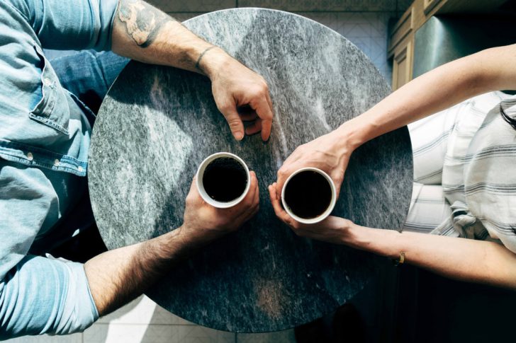 two person holding coffee