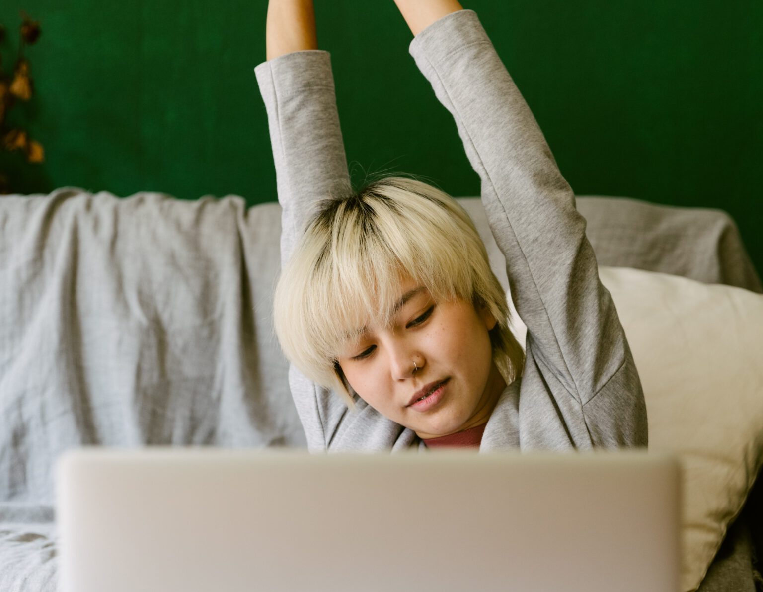 vrouw rek uit achter laptop