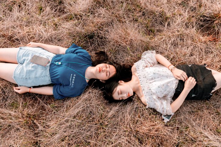 Twee meisjes liggen in het gras