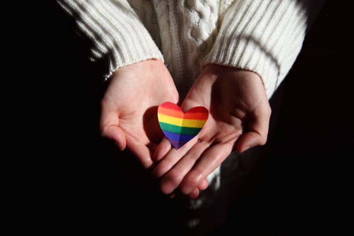 Persoon die symbool van de LGBTQ+ community vasthoudt