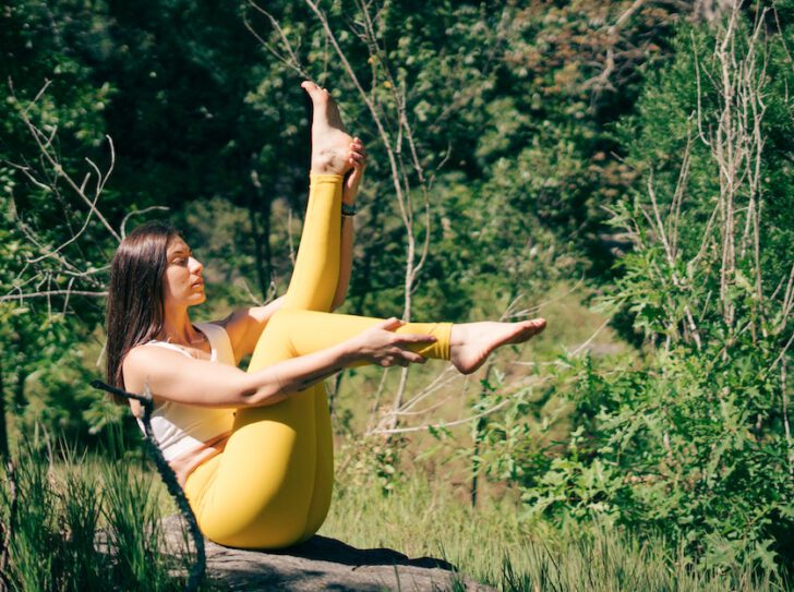 vrouw doet yoga in natuur