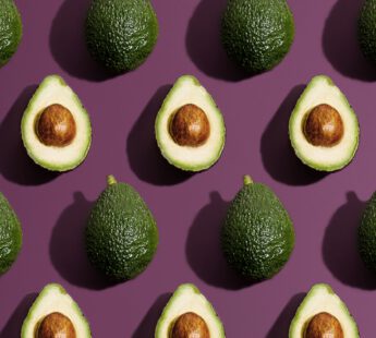 halve en hele avocado's op paarse achtergrond