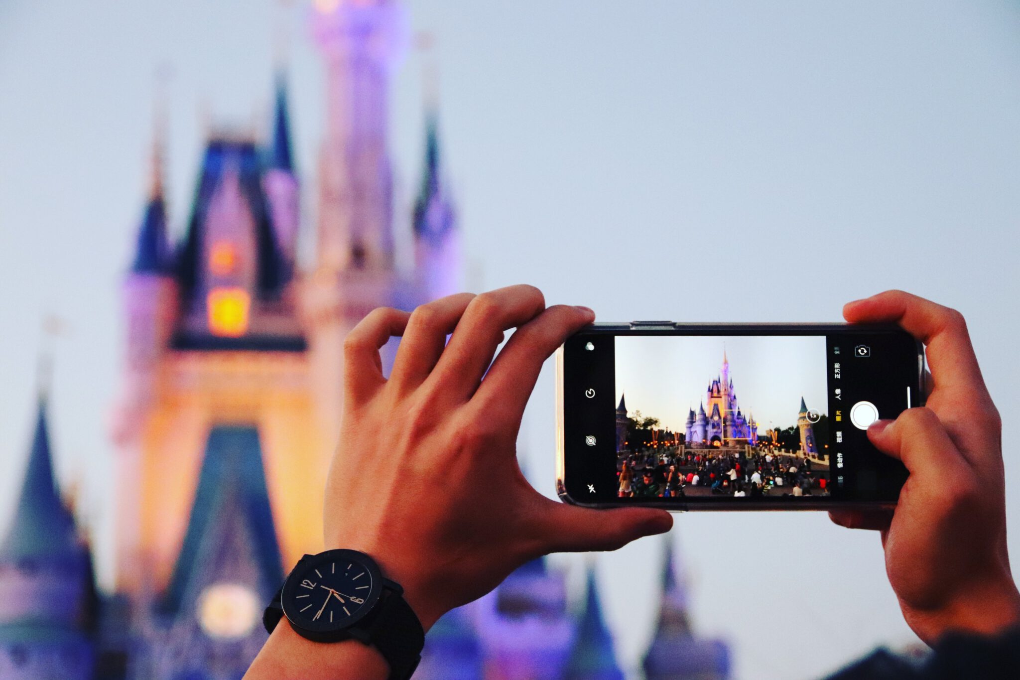 Persoon die foto maakt van kasteel in Disneyland met telefoon