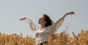 Mentale gezondheid, persoon staat met armen in de lucht