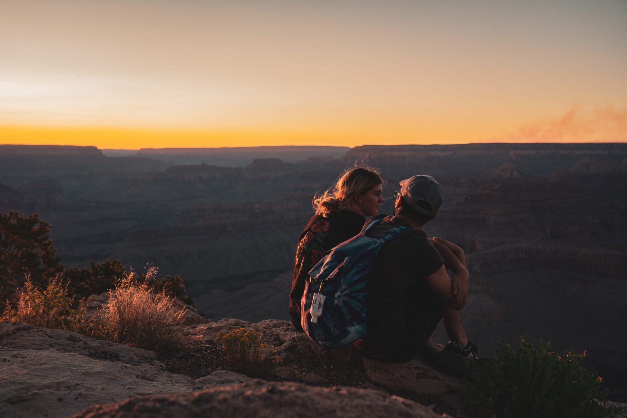 Te hoge verwachtingen relatie, stel zit op een rots te kijken naar de zonsondergang