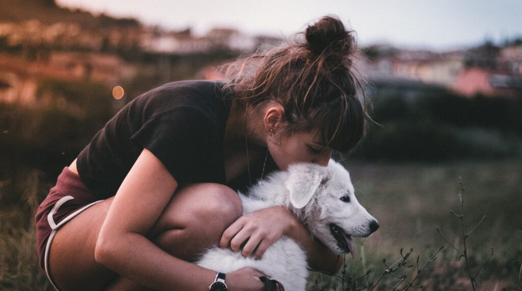 meisje knuffelt en kust haar hond