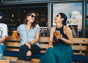 vrouwen drinken alcohol op bankje