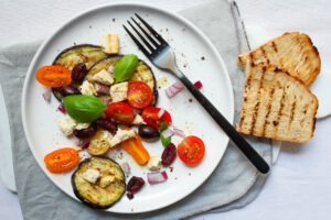 bord met tomaat, aubergine en olijven salade